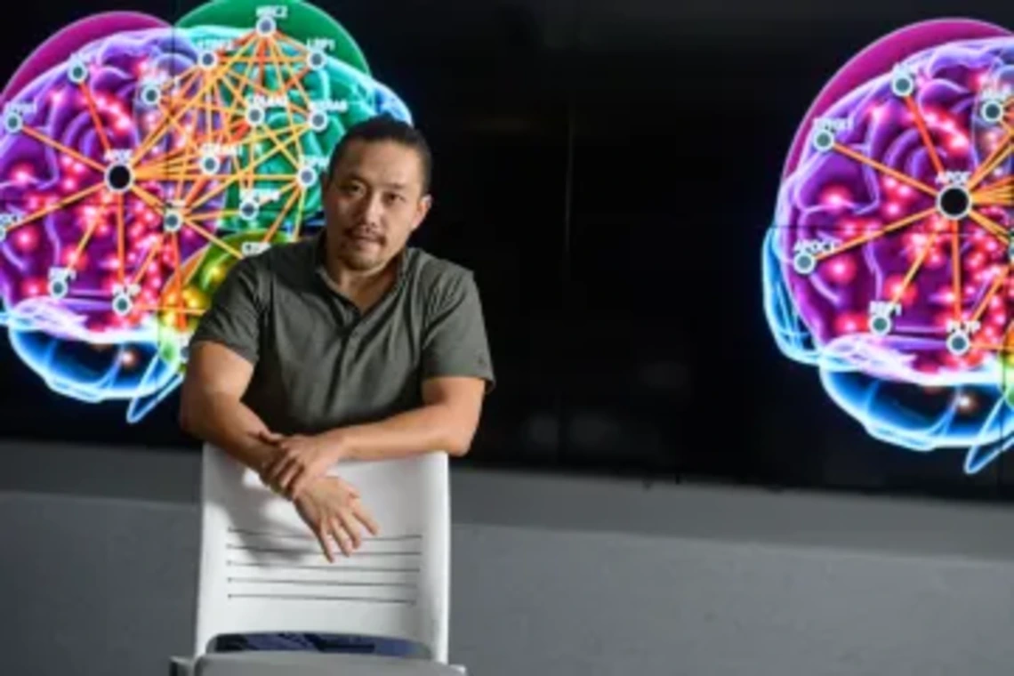 Associate Professor Rui Chang standing in front of monitor