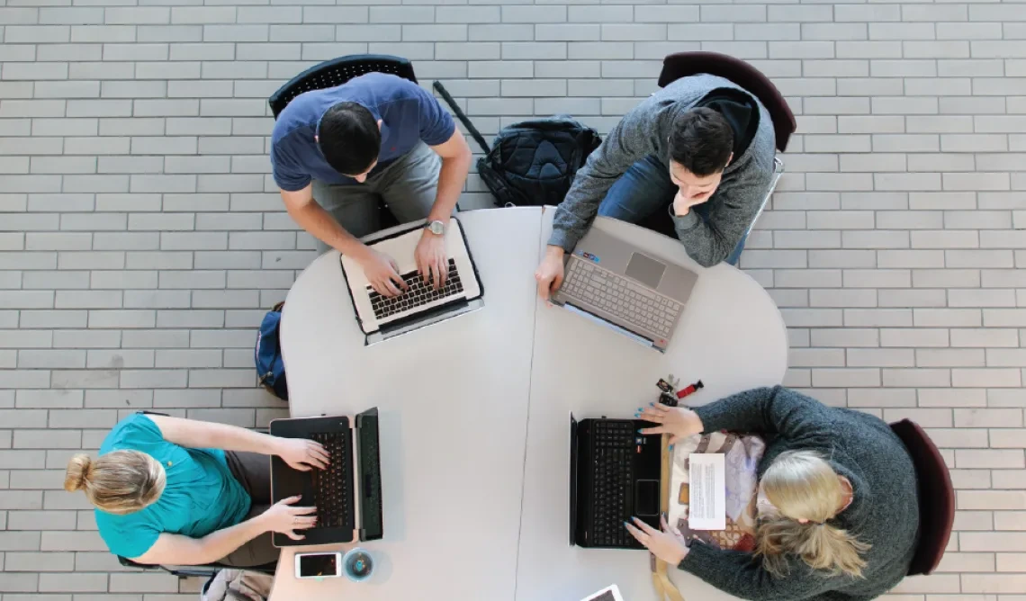 Aerial shot of students working on laptops at table